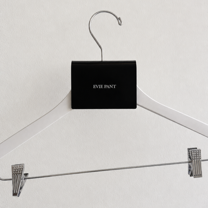 Front view of a black acrylic Evie Pant sign clip on a white hanger.