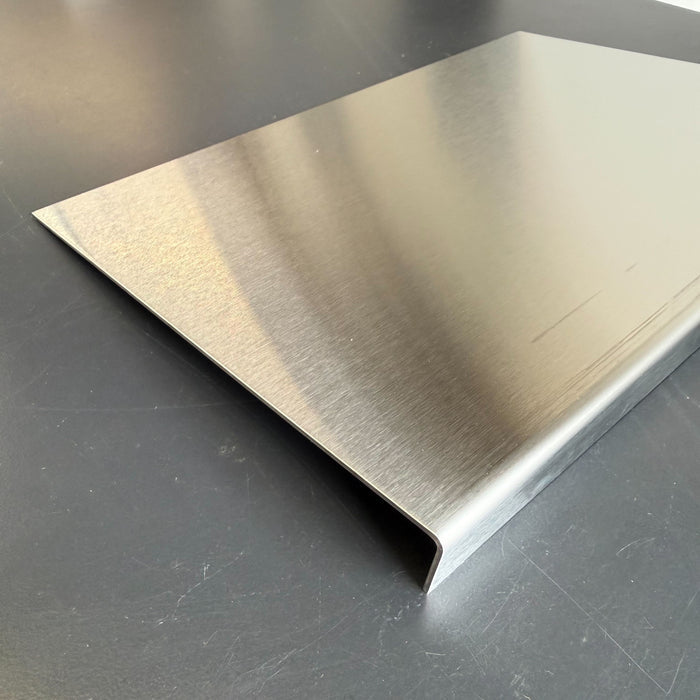 Side view of a low-profile stainless steel menu holder showing its folded edge.