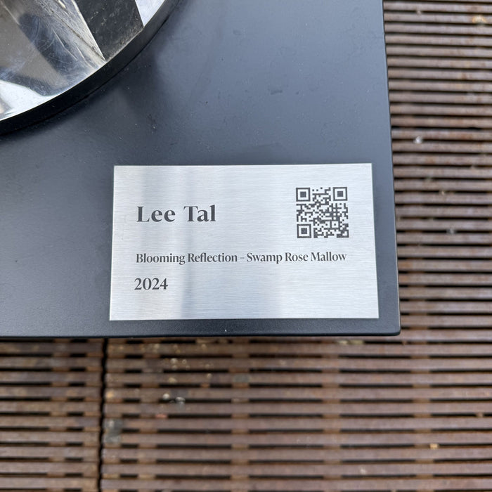Stainless steel gallery label with Lee Tal lettering and a QR code.