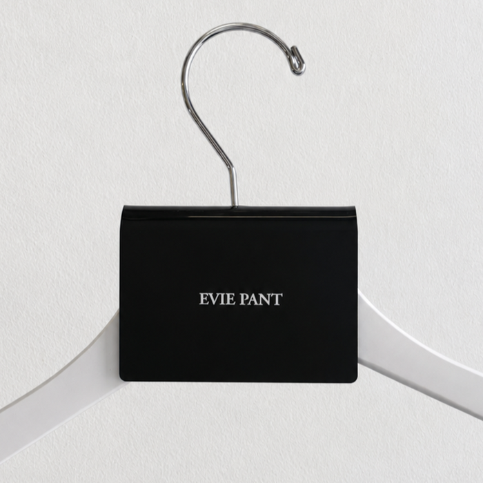 Black acrylic hanger sign clip with white Evie Pant lettering on a white hanger.