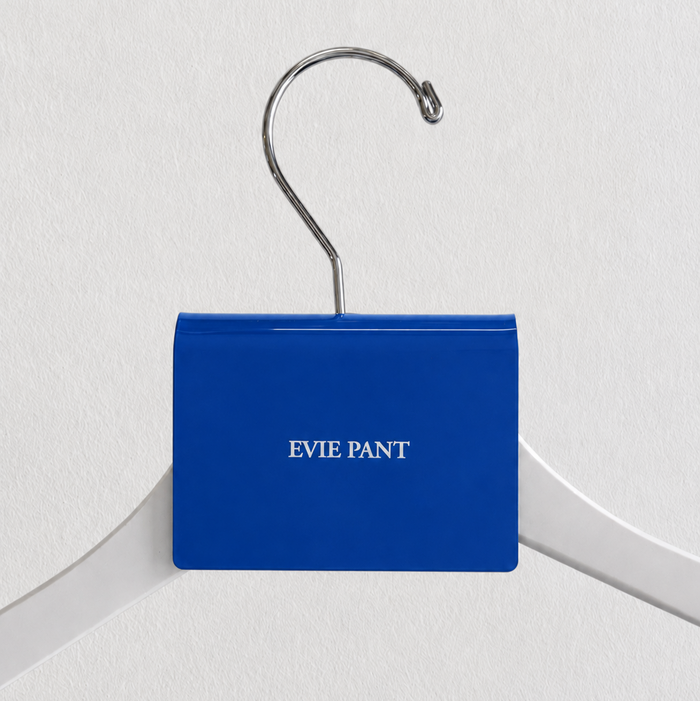 Blue acrylic hanger sign clip with white Evie Pant lettering on a white hanger.