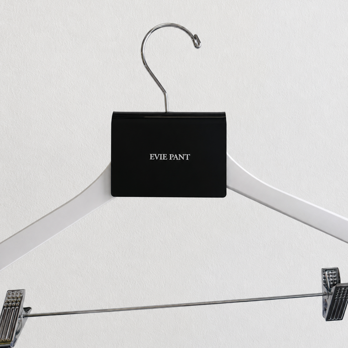 Black acrylic Evie Pant sign clip centered on a white trouser hanger.