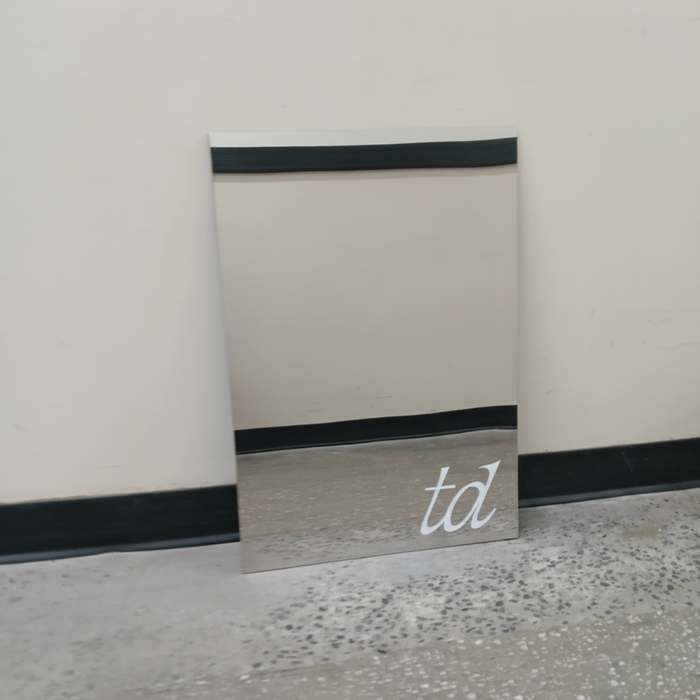 Mirrored leaning panel sign with a small white td logo.