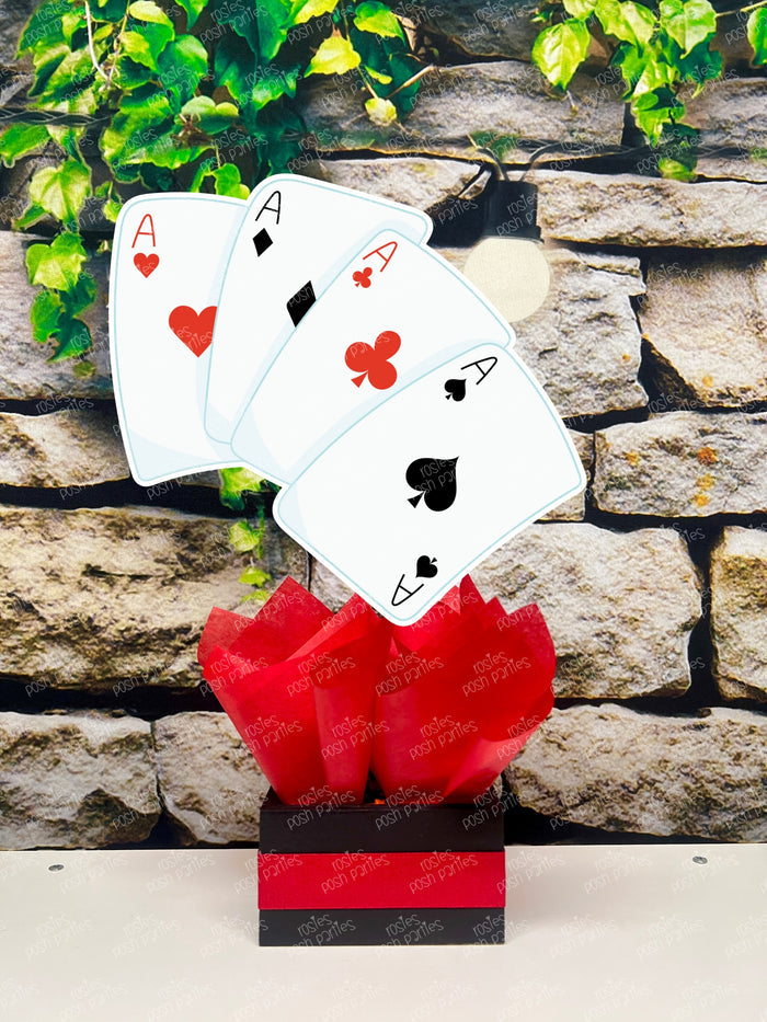 Kids birthday party magician themed centerpieces. The centerpieces feature illustrated cutouts including playing cards, a white rabbit in a tuxedo, a girl magician, a boy magician, a rabbit popping out of a top hat, and a magician's hat with a wand. Each cutout is set in a red, white, or black base filled with matching tissue paper. Receive fully assembled like pictured.