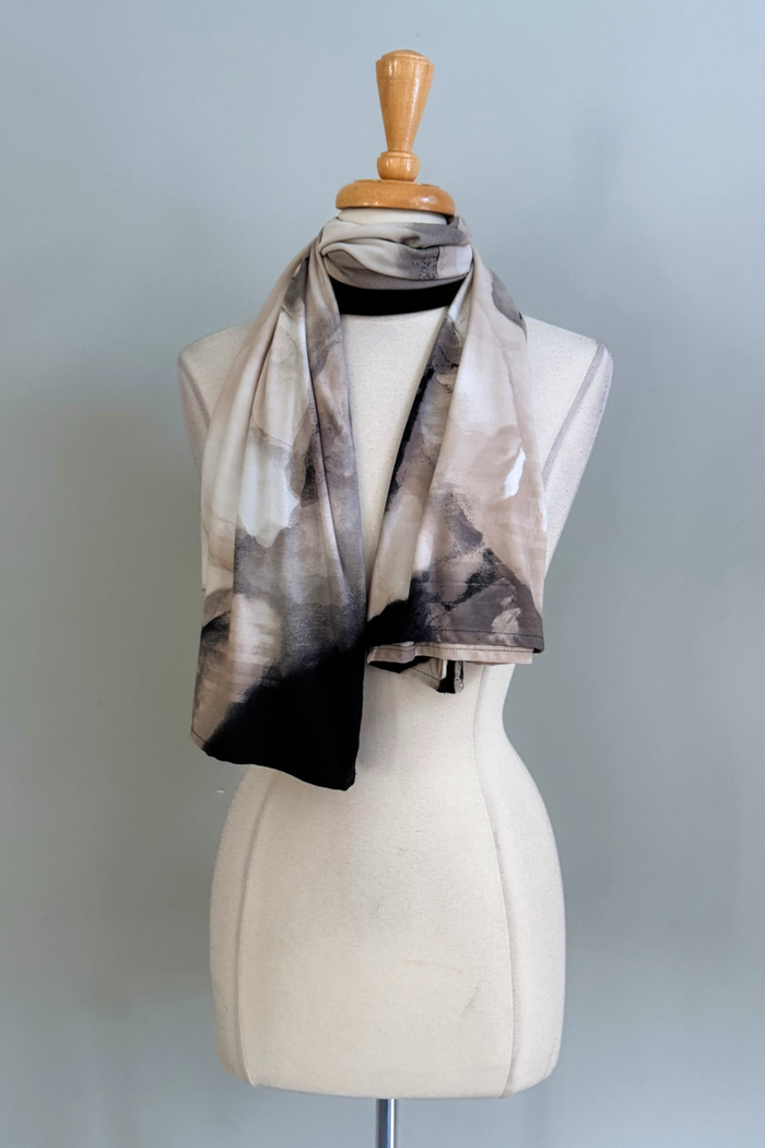 Oasis Sand print Carry-on Cozy worn as a scarf on a mannequin against a plain background