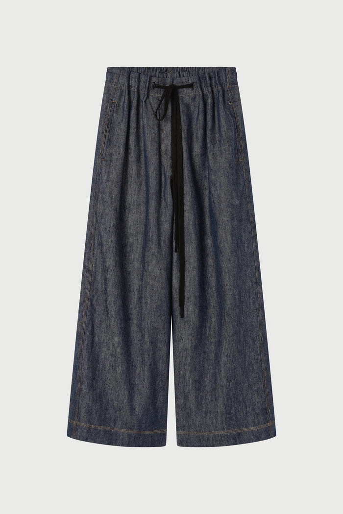 Dark blue denim pants with a drawstring on a light gray background