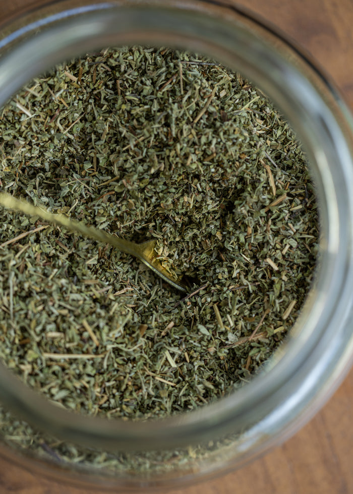 Close-up of a jar filled with dried herbs on a wooden surface