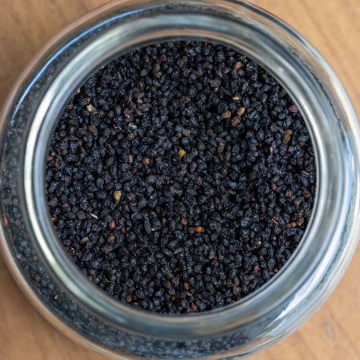 Close-up of a glass jar filled with black pepper on a wooden surface