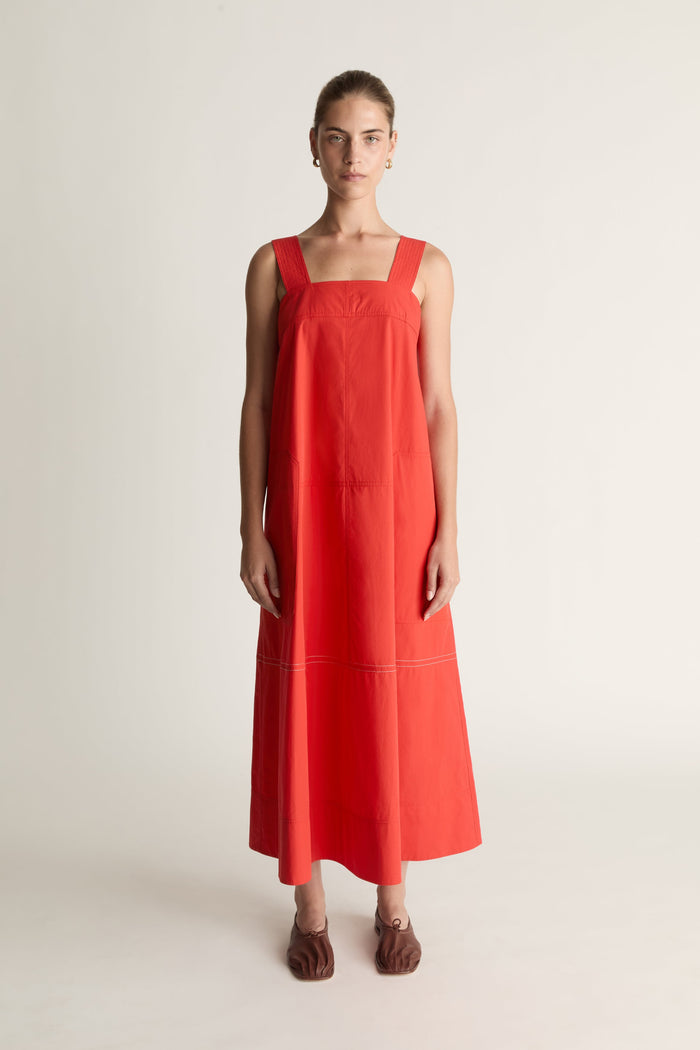 Woman wearing a red apron dress on a white background