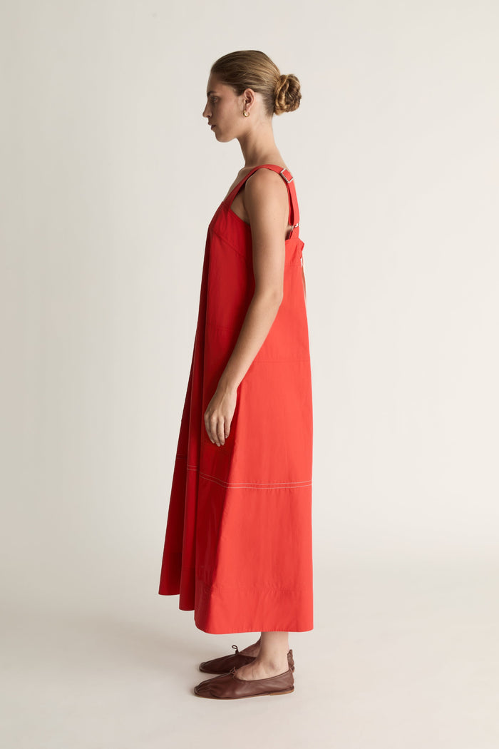 Woman wearing a red apron dress on a white background