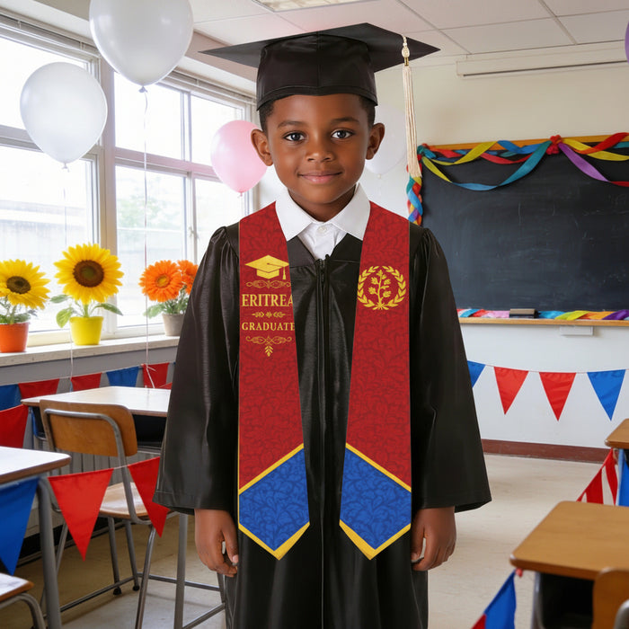 Young boy in graduation attire standing in a classroom with decorations.