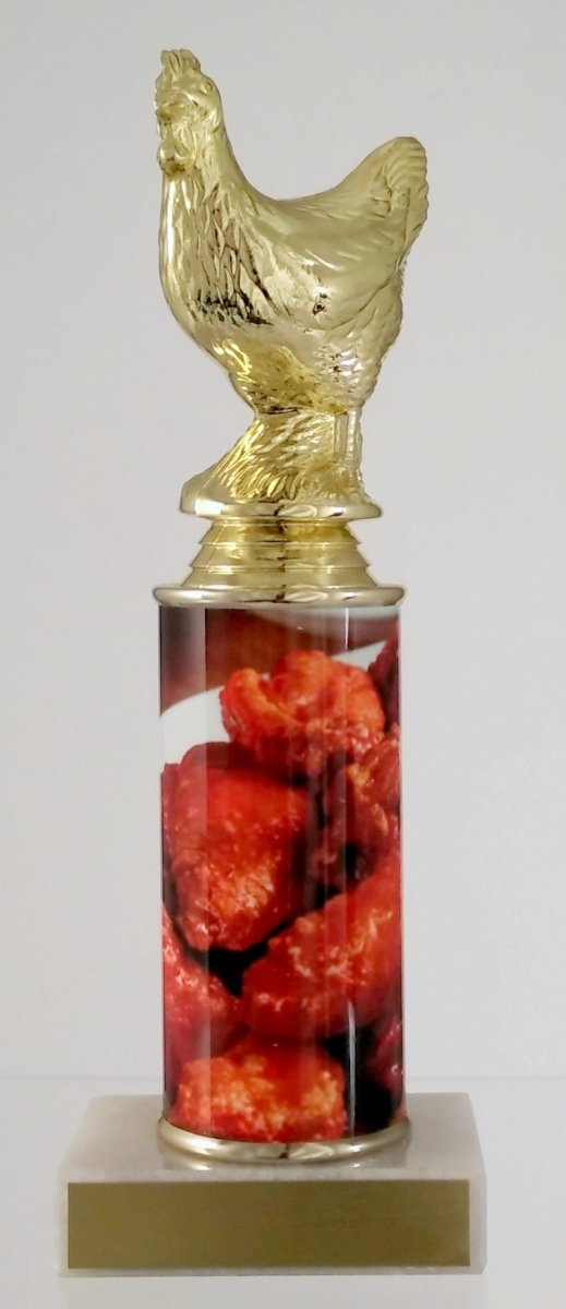 A trophy featuring a gold chicken figure on top of a column, with a base containing images of chicken wings. On top a white marble base with gold engraving plate.