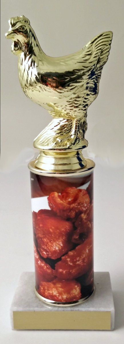 A trophy featuring a gold chicken figure on top of a column, with a base containing images of chicken wings. On top a white marble base with gold engraving plate.
