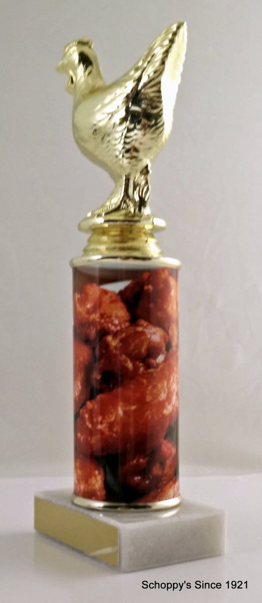 A trophy featuring a gold chicken figure on top of a column, with a base containing images of chicken wings. On top a white marble base with gold engraving plate.
