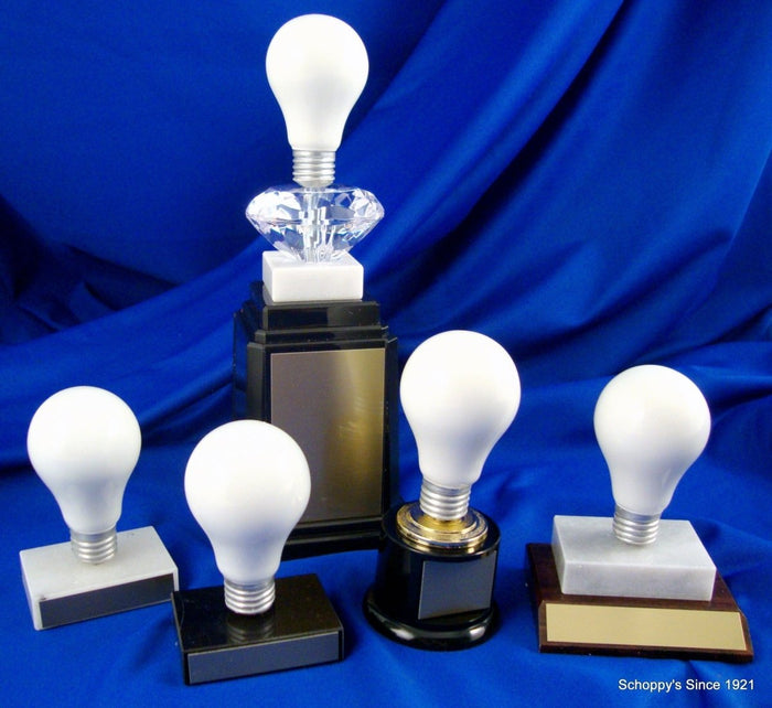 many light bulb trophies: White marble, black marble, slant wood base, black round base, black tower base