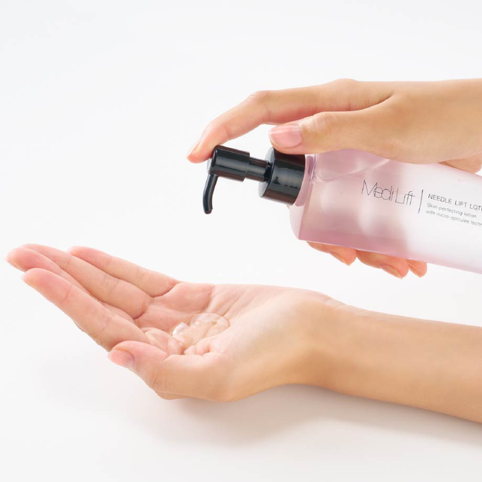 Hand holding a pink bottle labeled 'MedLift' with a pump, dispensing cream onto a palm.