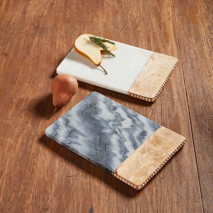 Beaded Wood and marble serving boards with tones of white, cream, blue, and gray.