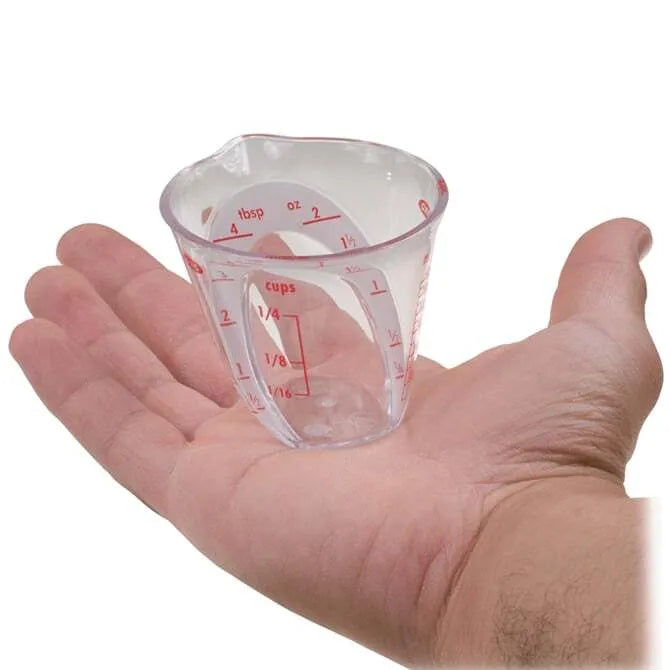 OXO Angled Measuring Cup 2oz Capacity handheld on white background