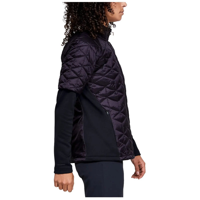 A person wearing a black and purple quilted jacket stands sideways with their arm slightly bent at the elbow in a neutral setting, showing casual outdoor wear suitable for cooler weather.